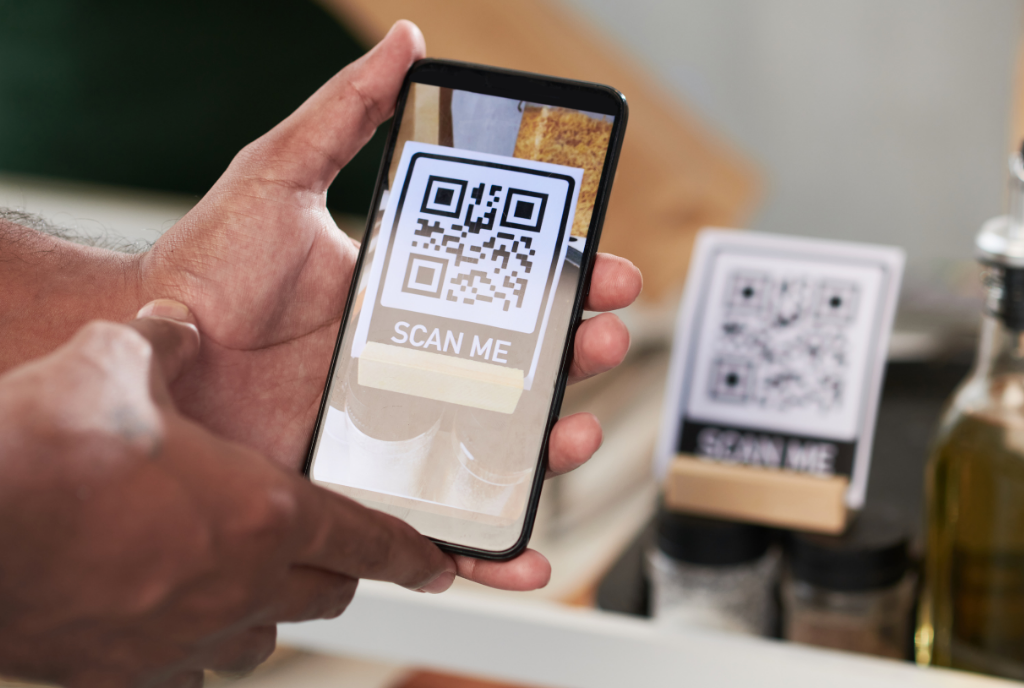 Hand holding phone scanning QR code