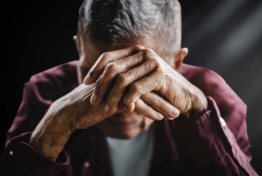 Elder with head in hands